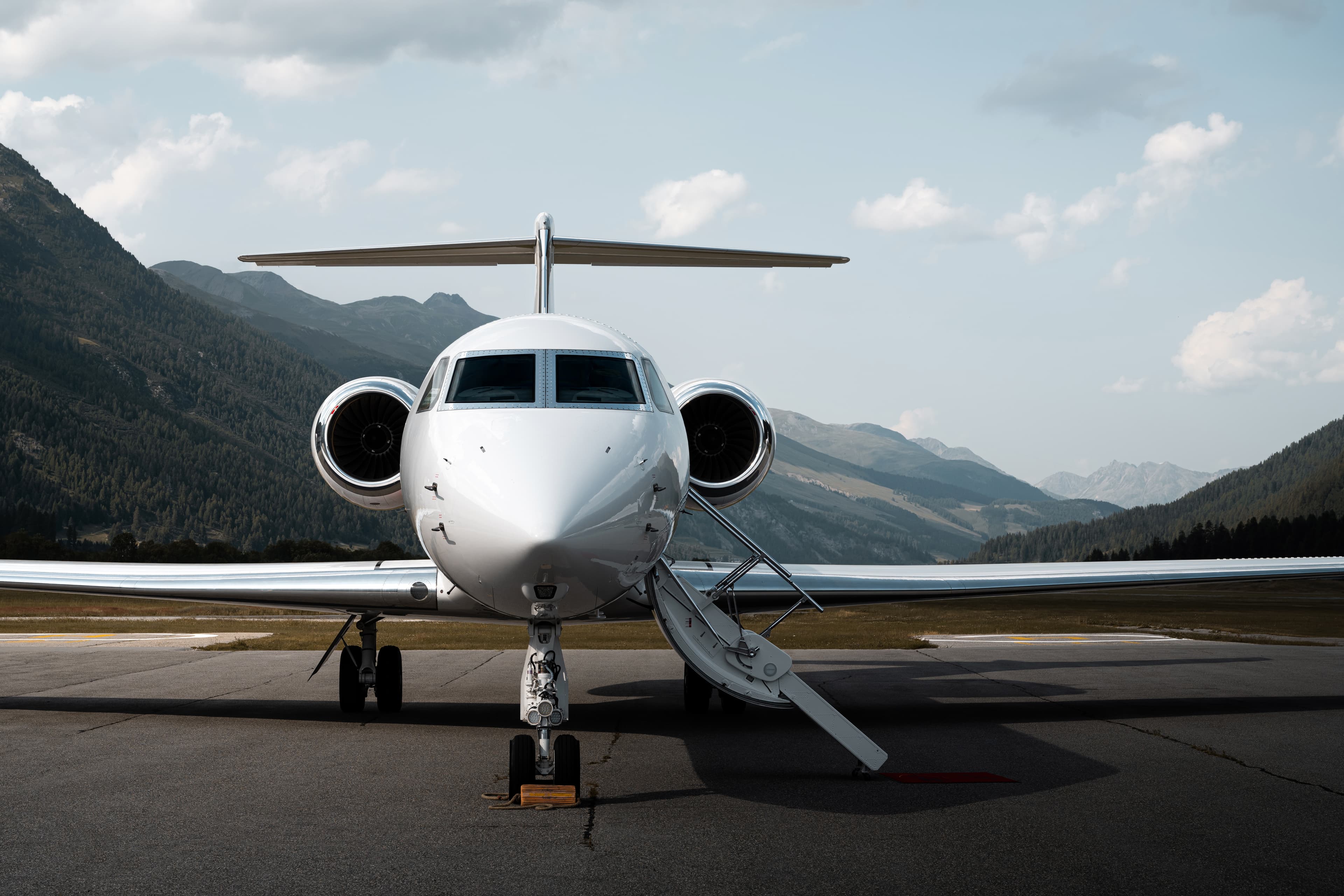 Private jet on tarmac with mountain backdrop